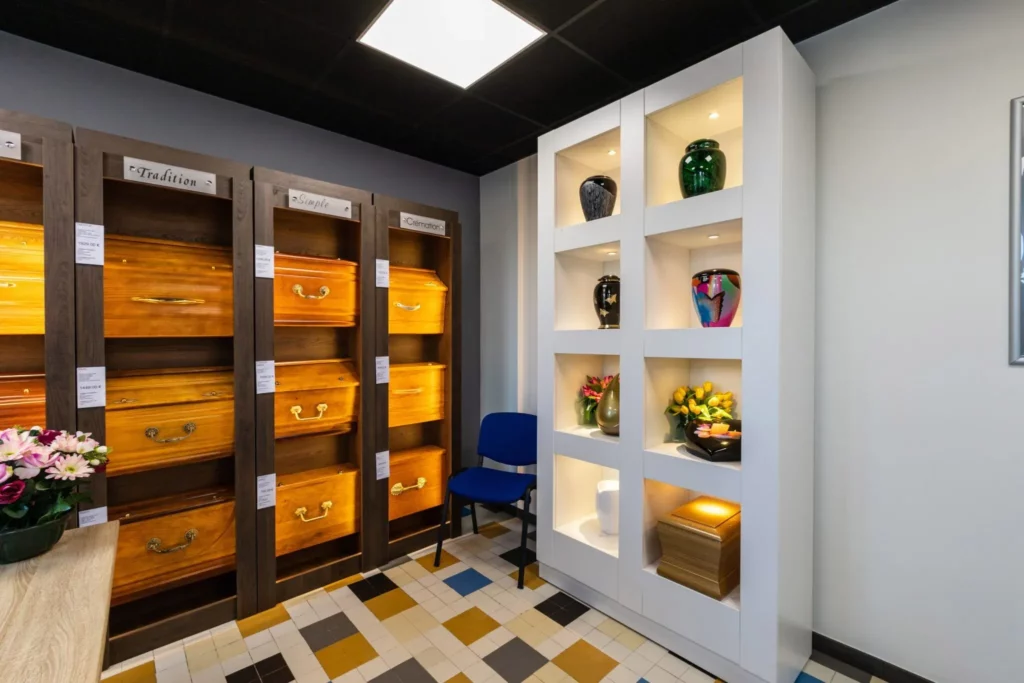 Exposition de cercueils et d'urnes funéraires dans le magasin de l'agence.