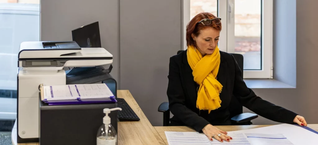Conseillère funéraire préparant les démarches administratives à son bureau.